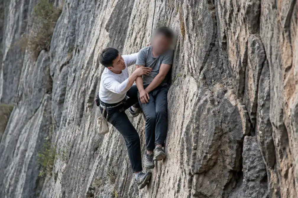 Student redt uitgeputte man van steile rotswand in China