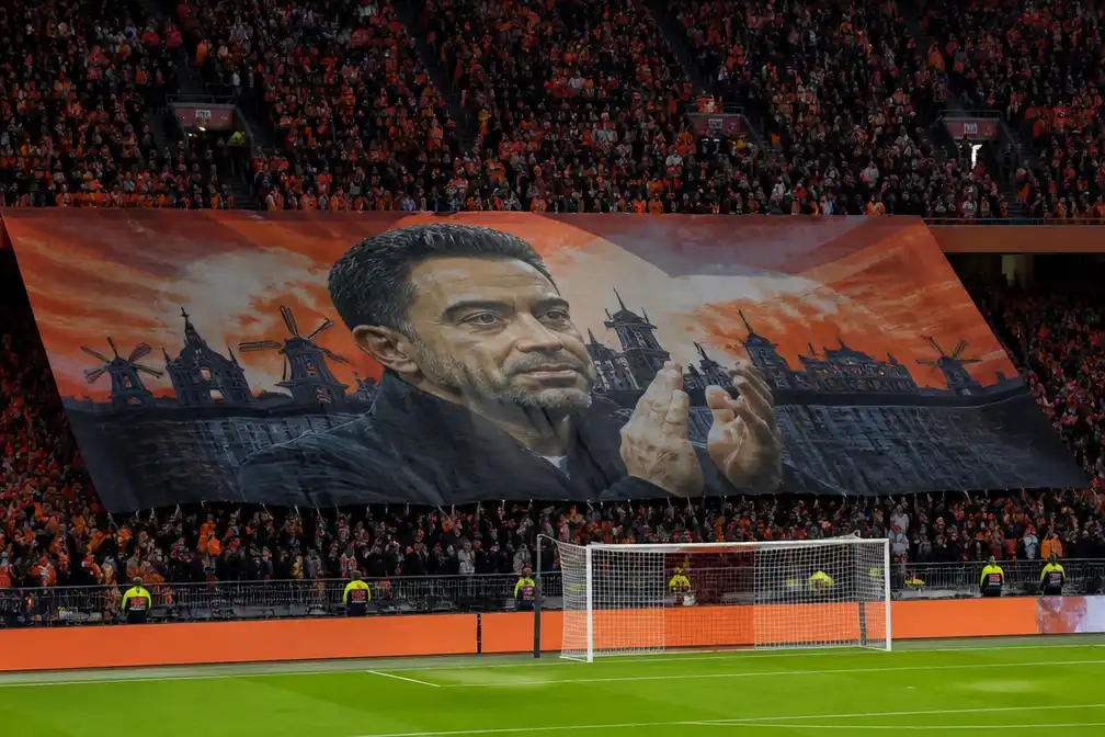 Oranje-supporters verwelkomen bondscoach Xavi Hernández met groot spandoek