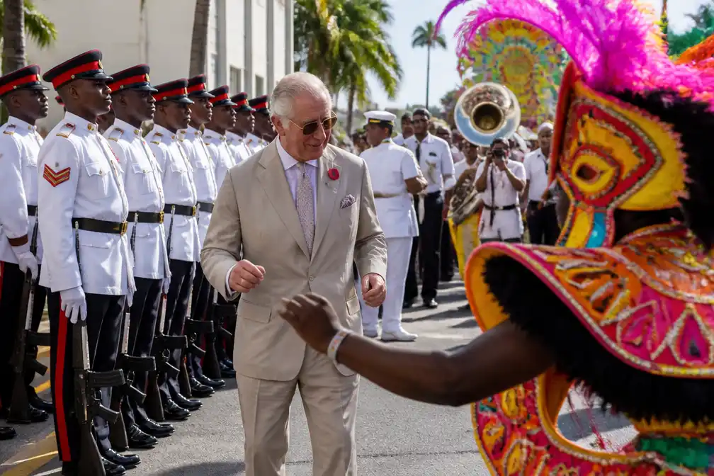 Koning Charles danst mee in junkanooparade in Nassau tijdens Caraïbische tour